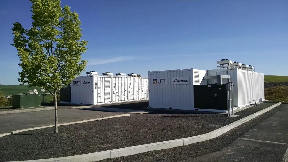 Containerised battery energy storage units on a prepared pad at an industrial site.